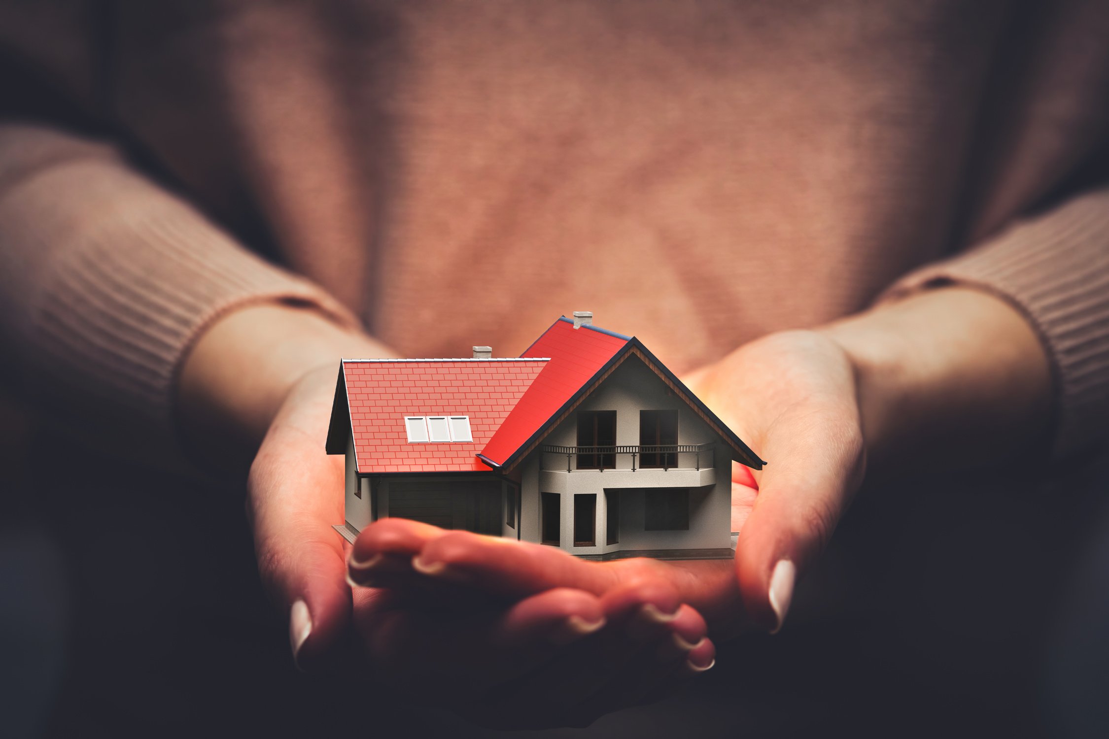 Home insurance, a house model safe in hands